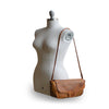 Brown woven leather bag with smooth flap on mannequin, Sawyer Woven Shoulder Bag.