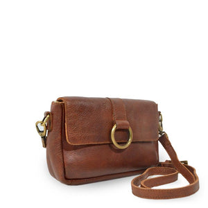 Small leather crossbody bag with a brass ring on the front, bag at an angle, Sabrina Crossbody Bag.